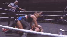 two wrestlers in a wrestling ring with # nxtuk on the back