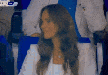 a woman sitting in a stadium watching a game with the score 24 3