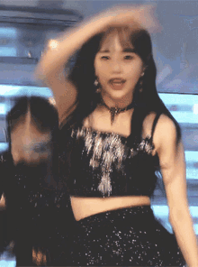 a woman in a black crop top is dancing