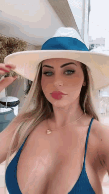 the woman is wearing a bikini and a hat .
