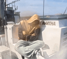 a person sitting on a boat with the name martha on it