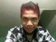 a young man with red hair is taking a selfie with his phone .