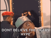 a man wearing a hat with the words " dont believe the tigers hype " on it