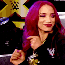 a woman with pink hair is wearing a black shirt with the letter w on it