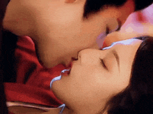 a man and a woman are kissing each other .