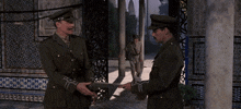 three men in military uniforms stand in front of a doorway