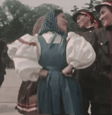 a woman in a blue dress is dancing in front of a group of men