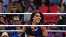 a woman in a wrestling ring with a sign that says damo