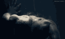 a man is laying in the water and his hand is reaching out