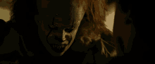 a close up of a scary clown with sharp teeth looking at a person .