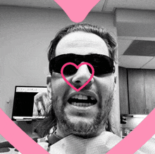 a man wearing sunglasses has a heart drawn on his nose