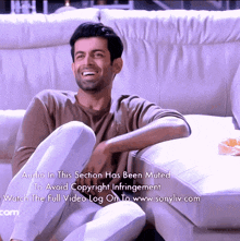 a man sits on a white couch with the words audio in this section has been muted on the bottom