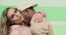 a man is kissing a woman on the cheek in a video .