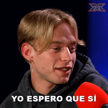 a picture of a young man with a red microphone and the words yo espero que si below him