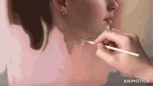 a person is painting a woman 's face with a brush and the words made in animatica on the bottom