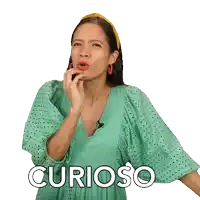 a woman in a green dress is making a face and the word curioso is below her