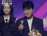 a man in a suit is holding a microphone in front of a woman in a microphone .