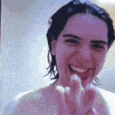 a woman without a shirt is smiling with her hands in front of her face