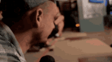 a man screaming into a microphone while wearing a baseball cap