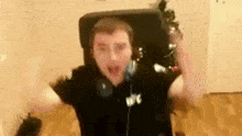 a man is sitting in a chair with his arms outstretched in a room with a christmas tree in the background .