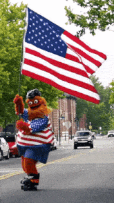 a teddy bear is riding a skateboard down a street while holding an american flag