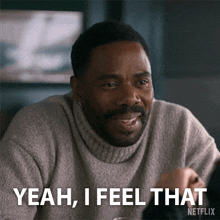 a man with a beard is smiling and says yeah i feel that