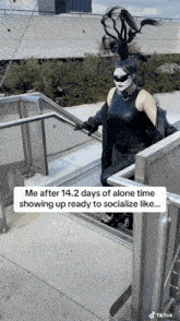 a woman in a black outfit is walking up a set of stairs