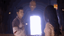 a man and a woman are standing next to each other in a dark room with a sony sab h3 logo on the bottom