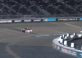a race car is going around a curve on a track with a sign that says ' busch ' on it