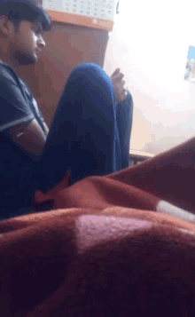 a man sits on the floor with his legs crossed and looks at his phone