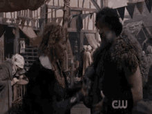 a man and a woman are standing next to each other in front of a crowd of people .