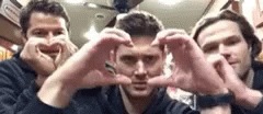 Three men, Castiel, Dean, and Sam from Supernatural making hears with their hands