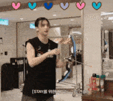 a man holding a bow and arrow in front of a mirror with hearts around him that say stay