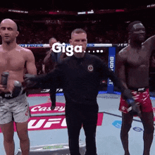 two men are standing next to each other on a boxing ring with a referee and the word giga on the screen .