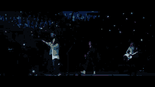 a crowd of people holding up their cell phones in the air