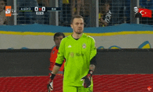 a soccer player in a green jersey with rain on it