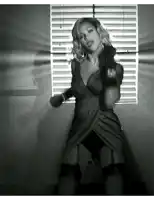 a woman is dancing in front of a window with blinds