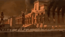 a very old building with a lot of statues on it is being destroyed by fire .