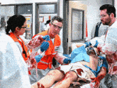 a man in an orange vest with the word emergency on it is being examined by a doctor