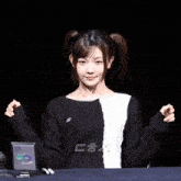 a girl in a black and white sweater is giving a peace sign