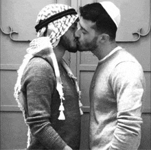 a man in a turban kisses another man on the forehead