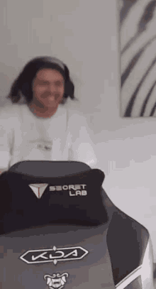 a man is sitting in a gaming chair with a pillow on it .