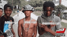 three men are standing next to each other on a sidewalk and one of them is wearing a hat and chains .