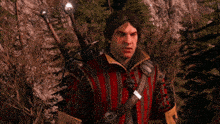 a man with a sword on his back stands in a forest