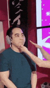 a woman is putting her hand on a man 's face .