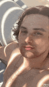 a shirtless man with a beard is taking a picture of himself