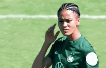 a female soccer player wearing a green jersey with the letter w on it