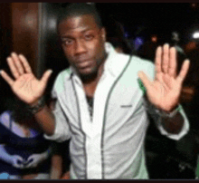 a man in a white shirt is waving his hands in the air