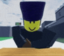 a cartoon character with a yellow face and a black hat is sitting on a table .