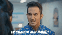 a man in a blue shirt is talking to a woman and says ek shabdh aur nah !!